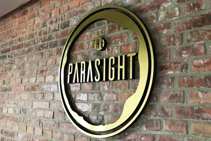 Kruhové 3D logo The Parasight na tehlovej stene — realizácia Neonworld